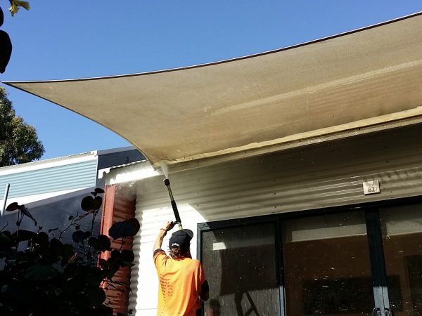Cleaning the underside of a canopy with a water jet.