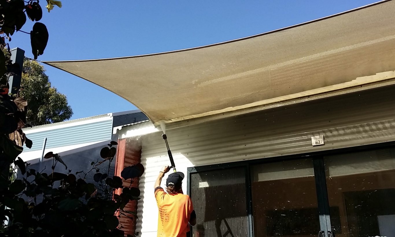 Cleaning the underside of a canopy with a water jet.